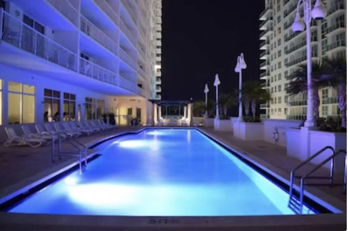 Heated pool lit at night at The Club at Brickell Bay