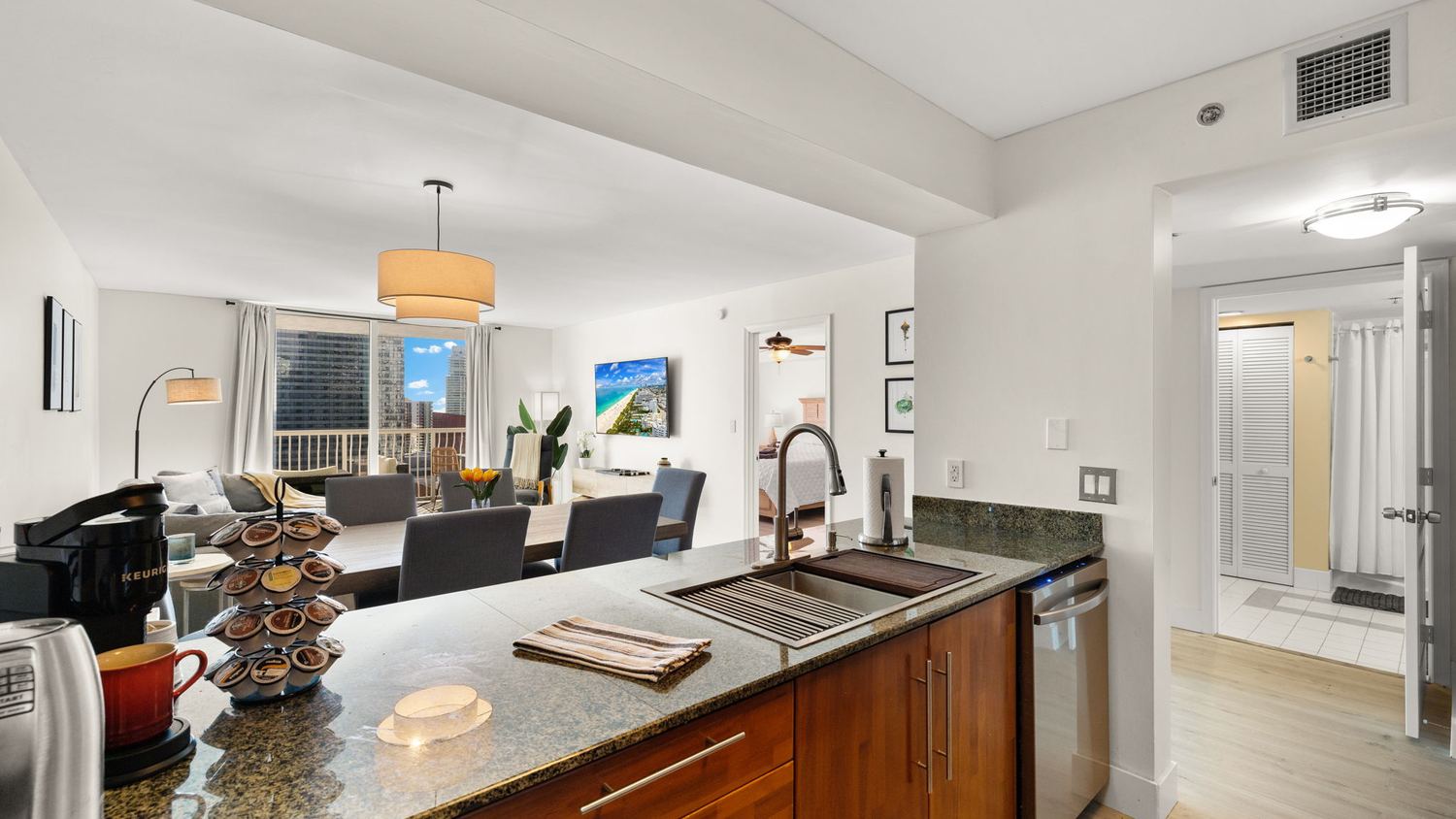 Kitchen island with coffee station looking across the dining area toward the balcony